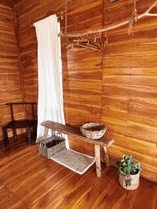 um quarto de madeira com um banco e uma cortina em La pipa Uluwatu em Uluwatu