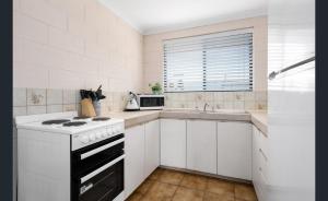 a white kitchen with a stove and a sink at WA Kalgoorlie Boulder Paddy's Golden Patch in Boulder