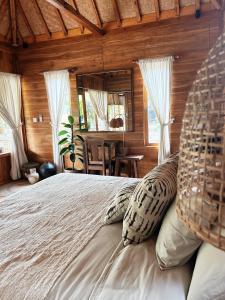um quarto com uma cama grande e almofadas em La pipa Uluwatu em Uluwatu