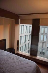 ein Schlafzimmer mit einem Bett und zwei großen Fenstern in der Unterkunft Acogedor y hermoso depto, en el C.Historico CDMX in Mexiko-Stadt