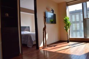 Zimmer mit einem Spiegel, einem Bett und einem TV in der Unterkunft Acogedor y hermoso depto, en el C.Historico CDMX in Mexiko-Stadt + 50 Fotos