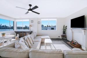 a living room with a couch and a tv at The Hillside at Hamilton - A Fresh Riverfront Abode in Brisbane