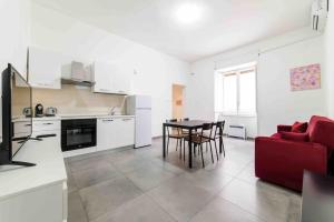 a kitchen and living room with a table and a red couch at [Incantevole Bilocale] Wi-Fi + Netflix in Salerno