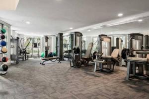 a gym with treadmills and machines in a room at Beautiful cozy suit in downtown in San Diego