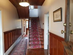 an empty hallway with stairs in a house at Riverhead Villa in Horoeke