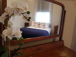 a mirror reflecting a bedroom with a bed and a window at Riverhead Villa in Horoeke