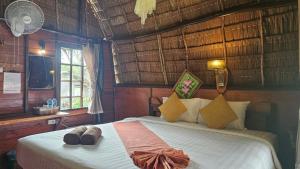 a bedroom with a bed with shoes on it at Eden Lanta Bungalow in Phra Ae beach