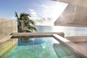 a swimming pool with a view of the ocean at LA PLAGE MARTINIQUE in Schœlcher