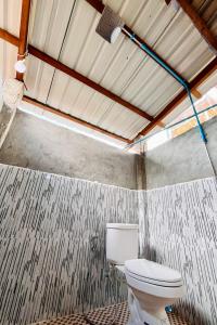 a bathroom with a white toilet in a room at Ratanakiri Farmhouse & Trekking in Banlung