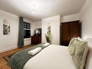 ein Schlafzimmer mit einem großen weißen Bett mit zwei Kissen in der Unterkunft Hannah’s Place Near Finsbury Park in London