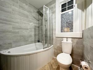 a bathroom with a toilet and a bath tub at Hannah’s Place Near Finsbury Park in London