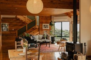 a living room with wooden walls and a fireplace at Buffalo Lodge in Coromandel Town