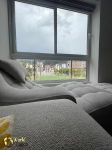 - une chambre avec un lit et une grande fenêtre dans l'établissement World Cusco, à Cusco