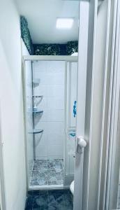 La salle de bains est pourvue d'une douche avec une porte en verre. dans l'établissement Departamento en urbanización privada, à Machala