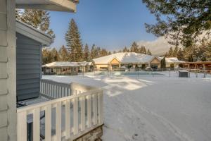 a house with a fence and a snow covered yard at RidgeView Resort in Radium Hot Springs