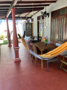 a room with a hammock and a table in a room at Easy Stay Lodge in Weligama