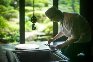 白山市川魚・山菜料理　和田屋的厨师在餐桌上用碗准备食物