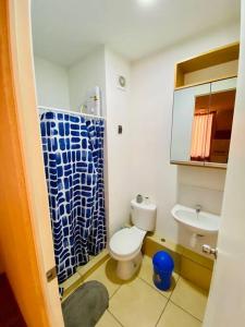 baño con aseo y cortina de ducha azul en Departamento amoblado en Piura