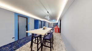 une salle à manger avec des murs bleus, une table et des chaises dans l'établissement Blue Lagoon At Bandar Sunway, à Petaling Jaya