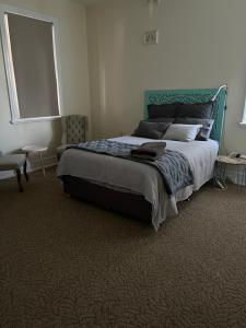 um quarto com uma cama grande e uma cabeceira verde em The Muddy Duck em Harden
