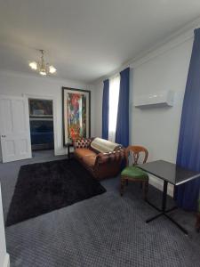 uma sala de estar com um sofá e uma mesa em Art Hotel on York em Launceston