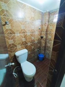 a bathroom with a toilet and a tiled wall at Home in Real in Cavinti