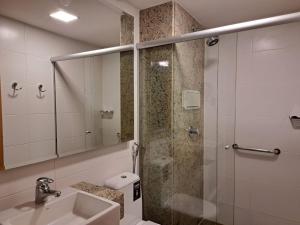 uma casa de banho com um chuveiro, um lavatório e um espelho. em BSB STAY Flats particulares - CULLINAN em Brasília