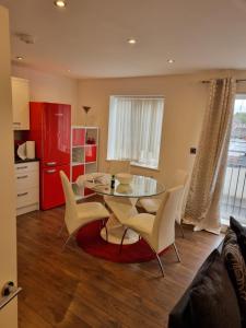 a kitchen and dining room with a glass table and chairs at C'S LUXURIOUS Flat in Barking