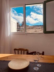 - une table avec une assiette et 2 verres à vin dans l'établissement Campo y lava, à Tías