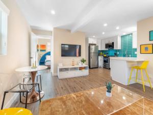 a living room with a kitchen and a dining room at Beach Bungalow Perfection - Private Patios, BBQ walk2beach & Pet Friendly! in San Diego