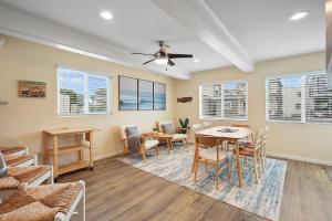 sala de estar con mesa, sillas y ventanas en Beach Perfection - Ocean Views, Parking, Pet Friendly & Steps2Sand en San Diego