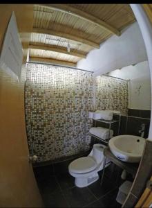 a bathroom with a toilet and a sink at Lobitos Eco Lodge in Lobitos