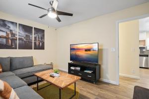 a living room with a couch and a flat screen tv at Beach Perfection - Ocean Views, Parking, Pet Friendly & Steps2Sand in San Diego