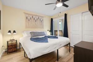 1 dormitorio con 1 cama blanca y ventilador de techo en Beach Perfection - Ocean Views, Parking, Pet Friendly & Steps2Sand en San Diego
