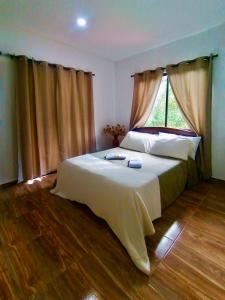 Schlafzimmer mit einem großen Bett und einem Fenster in der Unterkunft Mountain Lodge La Margarita in Quebradanegra