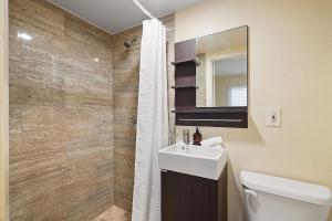 y baño con lavabo, aseo y espejo. en Stunning Beach Delight with Hot Tub, Fire Pit, Parking & Walk to Beach! en San Diego