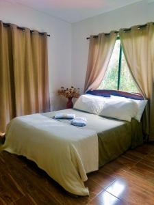 um quarto com uma cama grande e uma janela em Mountain Lodge La Margarita em Quebradanegra
