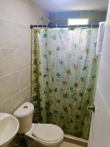 uma casa de banho com um WC e uma cortina de chuveiro em Mountain Lodge La Margarita em Quebradanegra