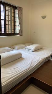 2 camas individuais num quarto com uma janela em 金蘭小築民宿 em Zhuqi