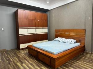 a bedroom with a bed with a wooden headboard at Linh' house in Ho Chi Minh City