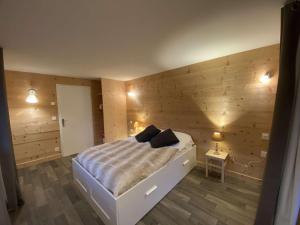 a bedroom with a bed with a wooden wall at Chalet familial spacieux et lumineux à 5 min du centre, avec balcon, Wi-Fi, proche des pistes - FR-1-342-312 in Beaufort
