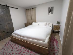 een slaapkamer met een groot bed met witte lakens bij Charming and Stylish Gem in Oak Park