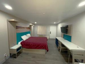 a bedroom with a bed with a red bedspread at New Star Inn El Monte, CA - Los Angeles in El Monte