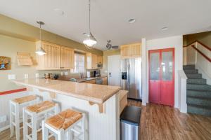 a kitchen with a counter and a red door at Bayfront Paradise- Bay Views & Boardwalk Patio in San Diego