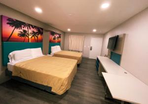 um quarto de hotel com duas camas e uma televisão de ecrã plano em New Star Inn El Monte, CA - Los Angeles em El Monte