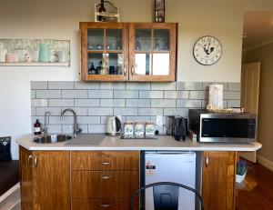 a kitchen with a sink and a microwave at The Nest - Relax & Unwind with Breathtaking Views over Lake Taupo in Taupo