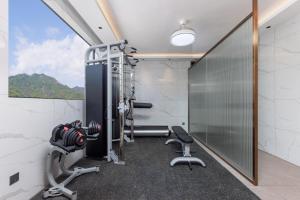 a gym with exercise equipment in a room with a window at Guangzhou Yachen Hotel in Guangzhou