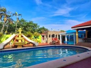 una piscina con un tobogán de agua en un patio trasero en 3B Cozy home, en Mauban