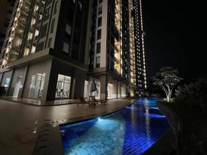 a building with a swimming pool at night at Apartment TransPark Cibubur, TSM in Kalimanggis