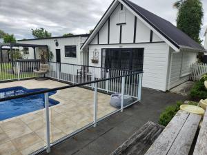 a backyard with a pool and a house at Cedar House in Gisborne
